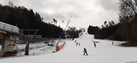 Lyžaři na sjezdovce pod lanovkou