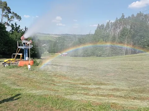 Sněžné dělo na letním svahu a duha